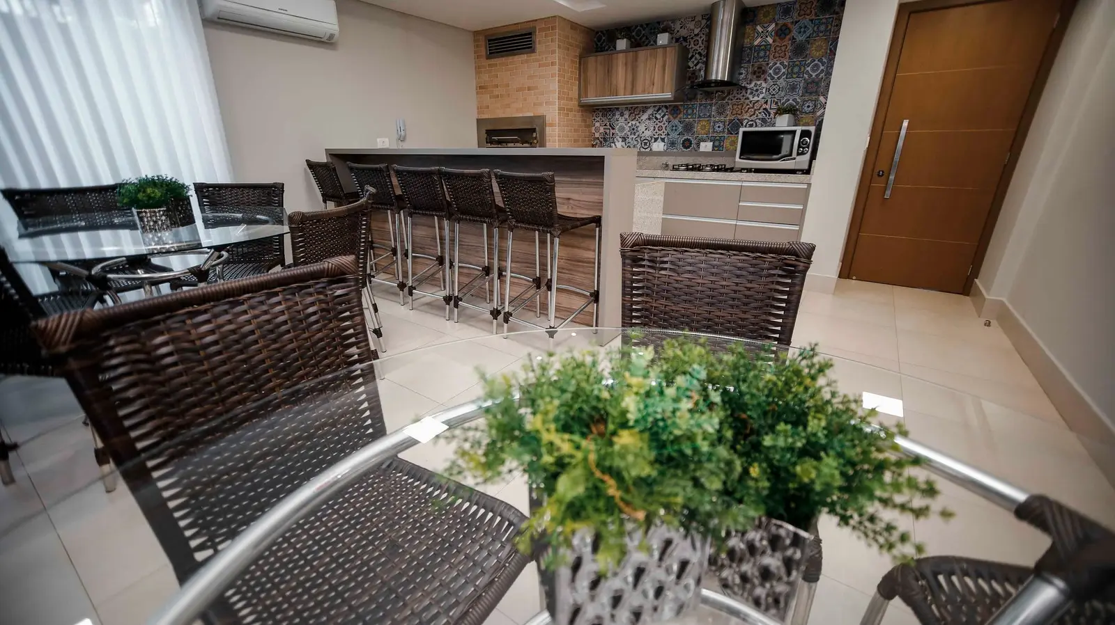 Cozinha com bancada, banquetas e azulejos decorados