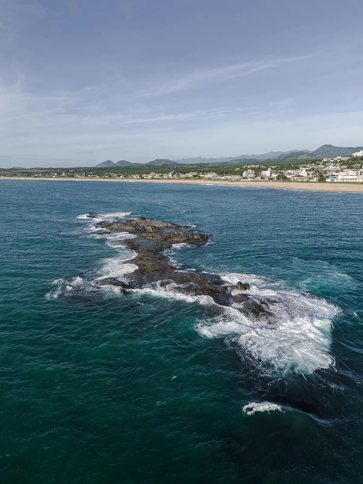 Costão de pedras e ondas na costa de Guarapari, vista do alto