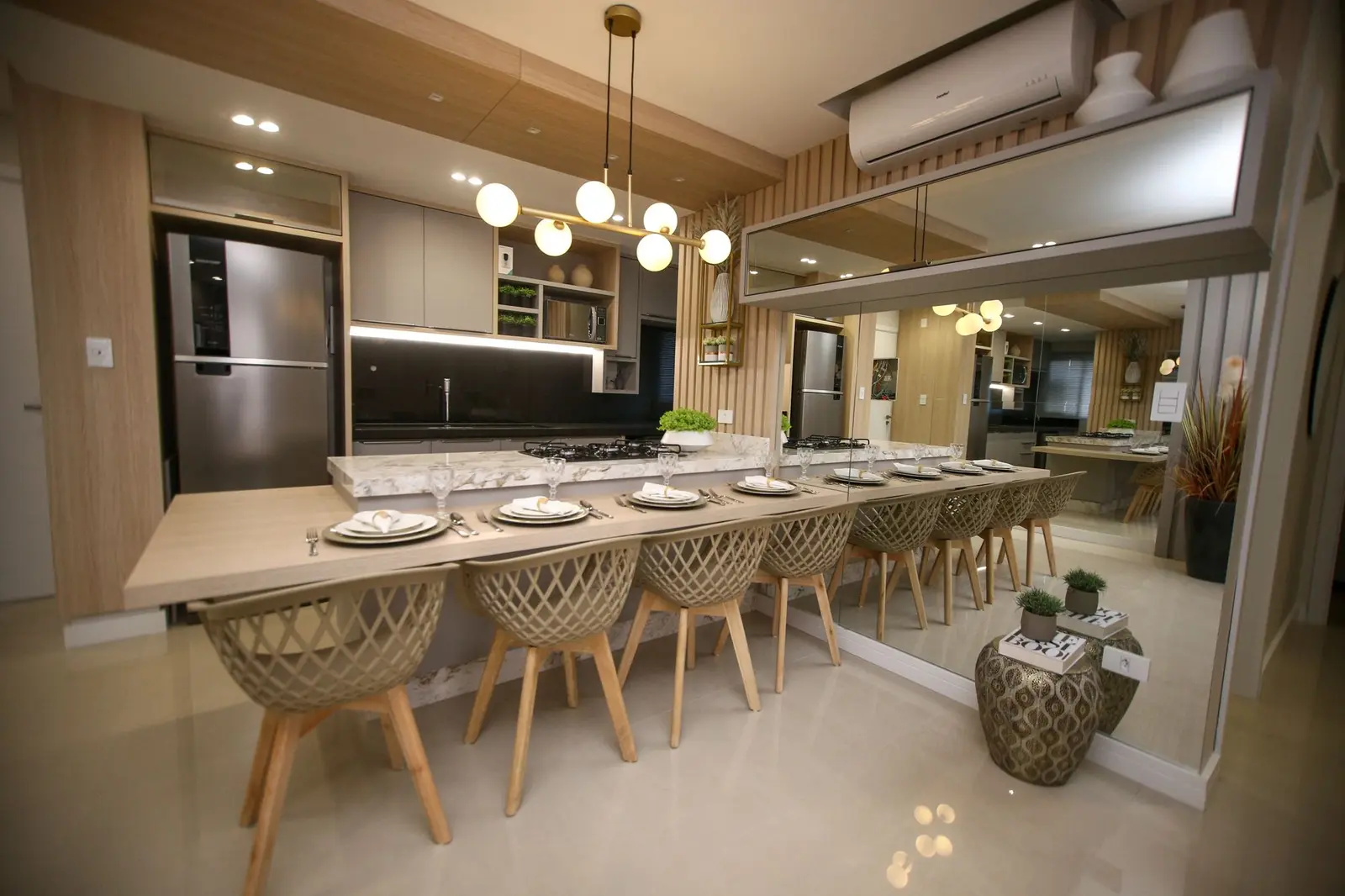 Cozinha com ilha de mármore e mesa comprida para oito