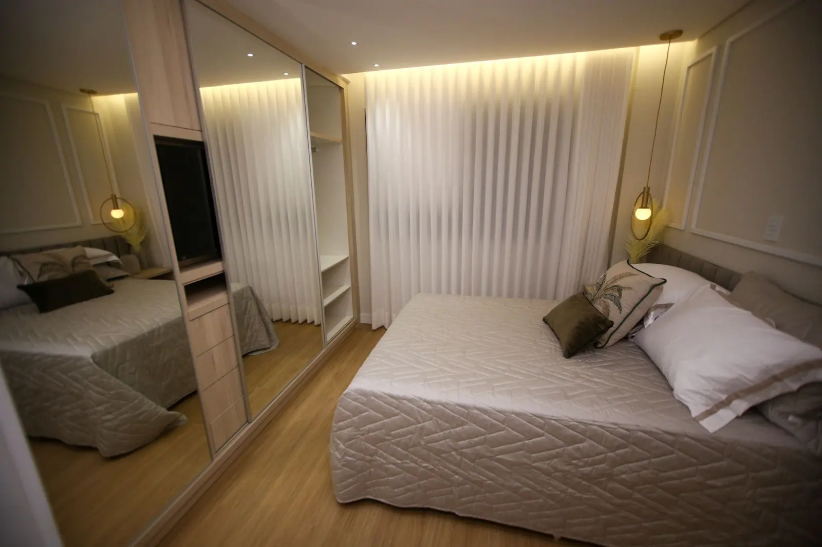 Quarto de casal com cortina clara e iluminação indireta