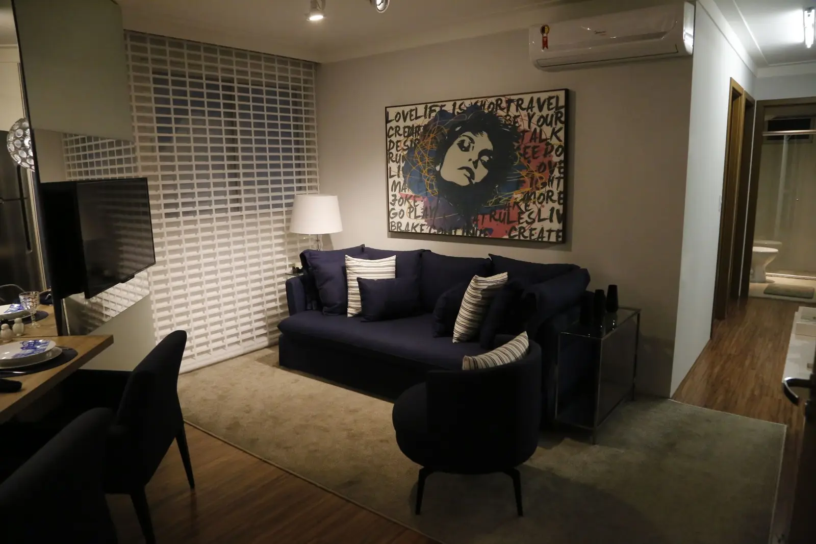 Sala com sofá azul-marinho e quadro grande na parede