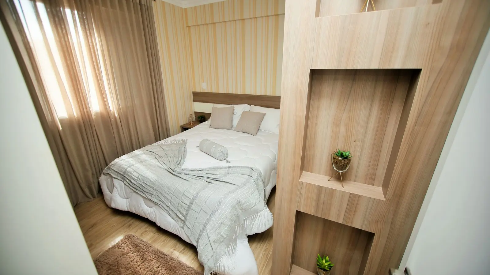 Quarto de casal com painel de madeira e janela