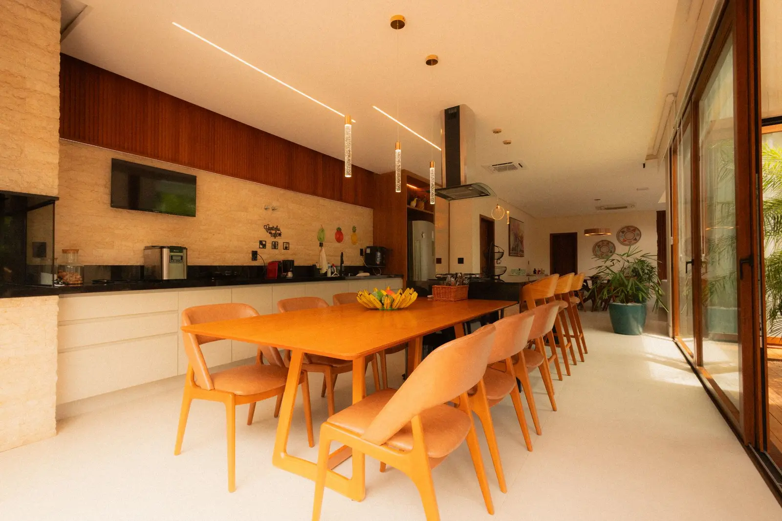 Cozinha com marcenaria de madeira e mesa para oito