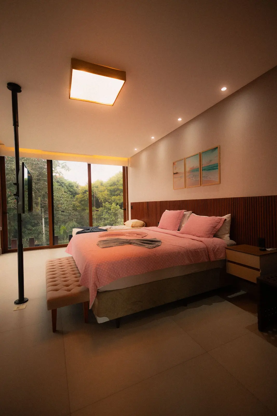 Quarto de casal com parede de vidro voltada para a mata