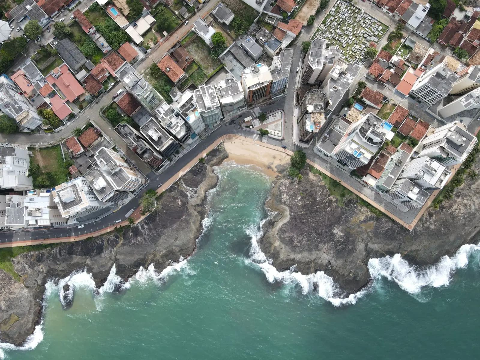 Costa de Guarapari vista do alto, com casas e ondas nas pedras
