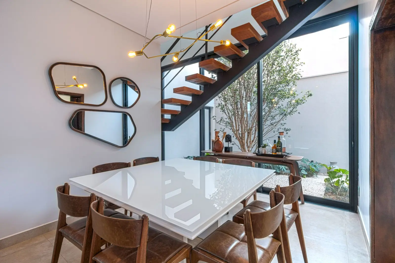 Mesa de jantar ao lado da escada para o andar de cima