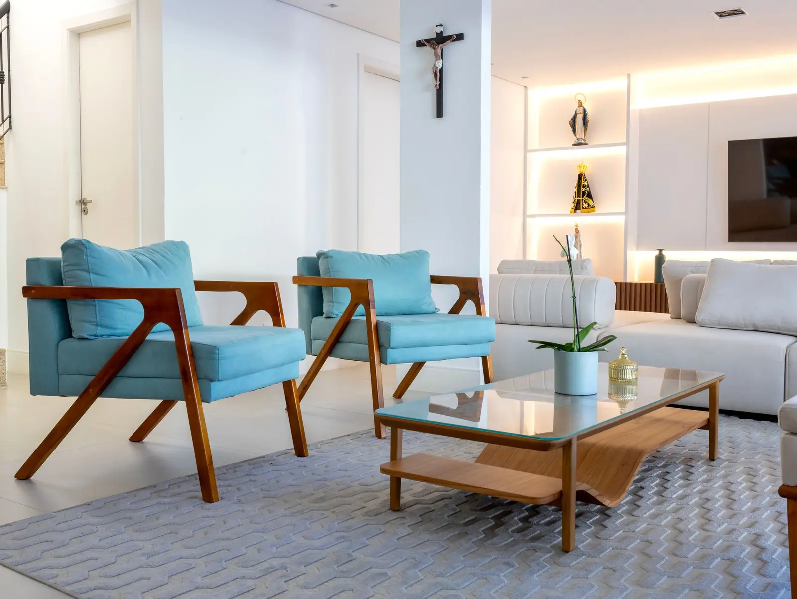 Poltronas azuis e sofá em L na sala de estar