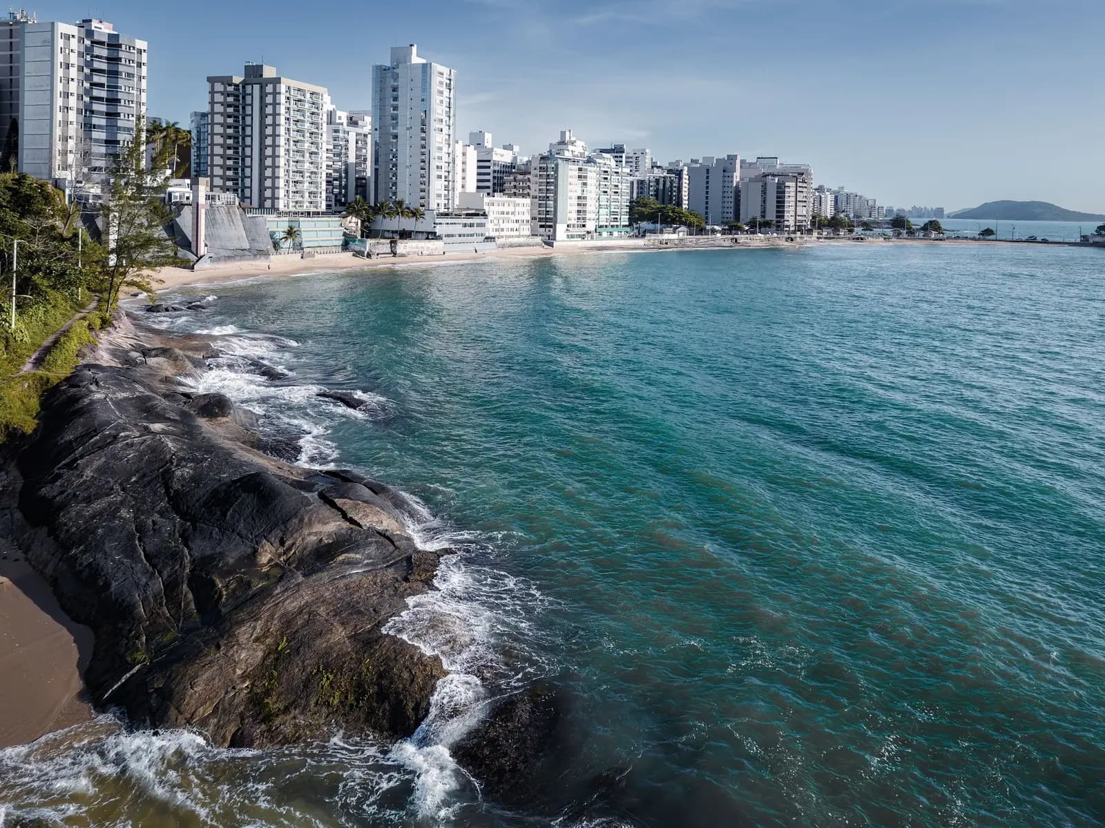 Orla de Guarapari vista do alto, com a areia e os prédios à beira-mar