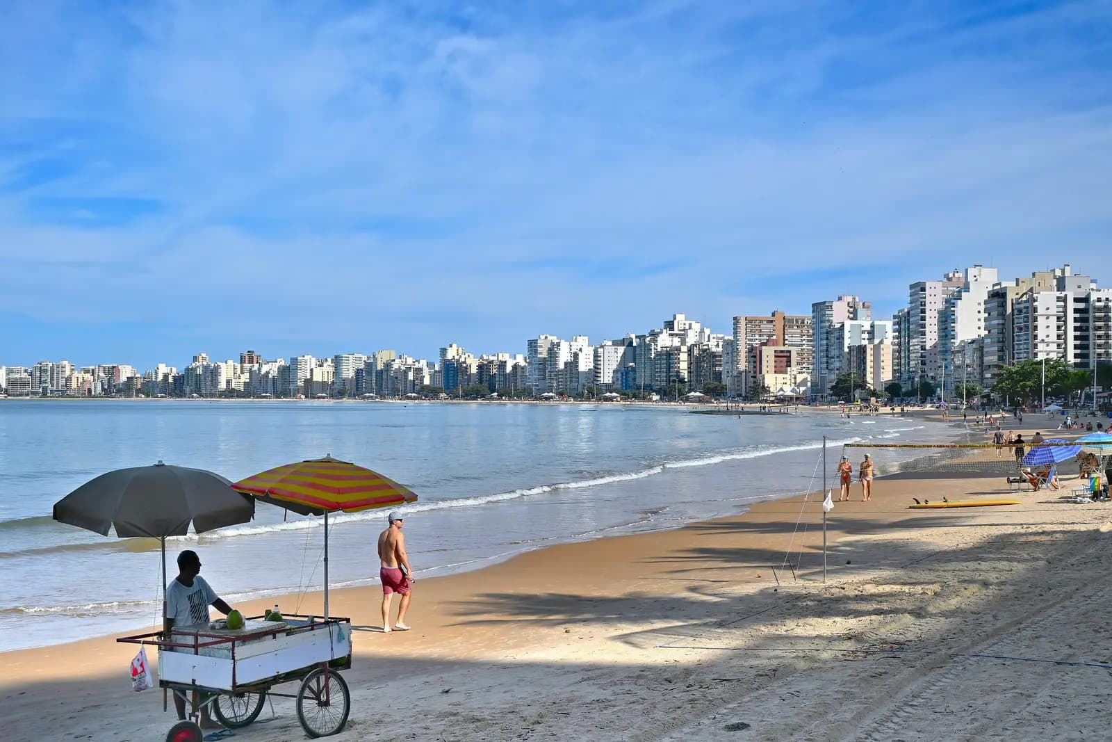 Praia do Morro, em Guarapari, com guarda-sóis e carrinho de praia