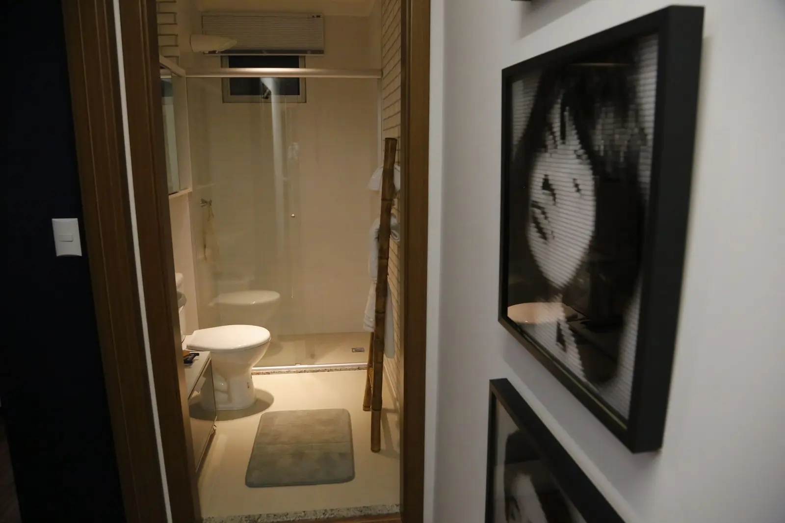 Banheiro com box e quadro em preto e branco